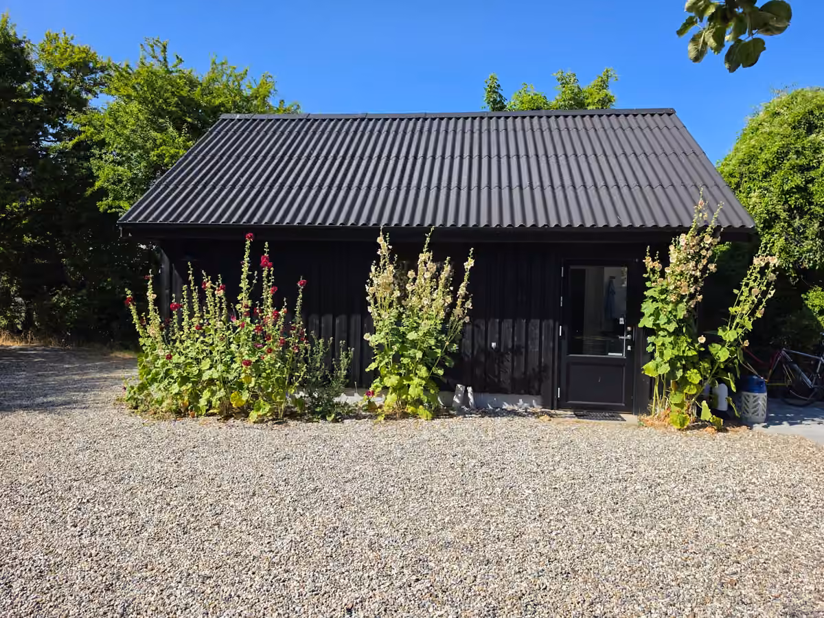 Den sorte garage med blomster langs facaden